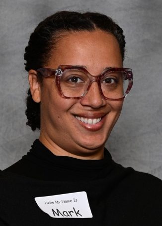 Person wearing maroon glasses and name tag reading Mark.