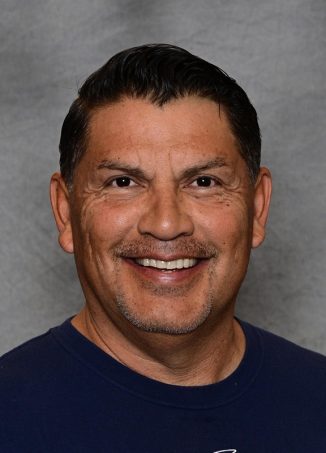 Man in dark blue shirt smiling at camera