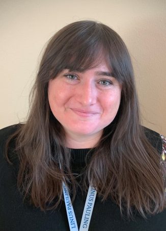 Professional headshot of woman wearing lanyard badge with floral patterned sleeve.