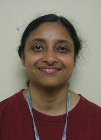 Woman wearing maroon shirt and blue lanyard smiling