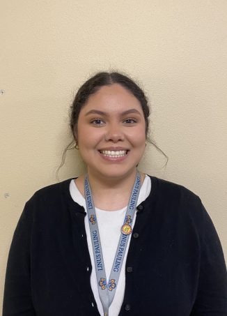 Student wearing school lanyard smiles at camera