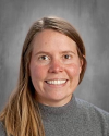 Woman with blonde hair smiling at camera, professional headshot.