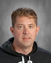 Middle-aged man with light brown hair wearing black hoodie.
