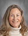 Woman with long blonde hair wearing cream-colored turtleneck sweater