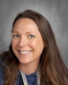 Professional headshot of smiling woman with long brown hair.