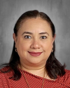Woman with long dark hair wearing red polka dot shirt