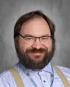 Man with glasses and beard wearing light blue shirt