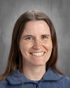 Woman with long brown hair smiling at camera