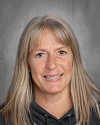 Woman with long gray hair smiling at camera