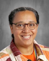 Man wearing glasses and orange collared shirt, professional headshot.