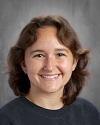 Woman with shoulder-length brown hair smiling at camera.